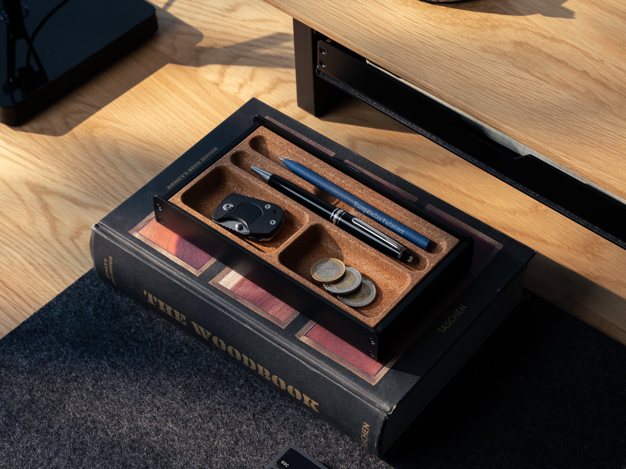 Totalaufnahme des Organizers für die Stiftablage in All Black. Ausgeschnitten auf grauem Hintergrund. Veranschaulicht mit SD Karten, Stift und Münzen. #material_All Black