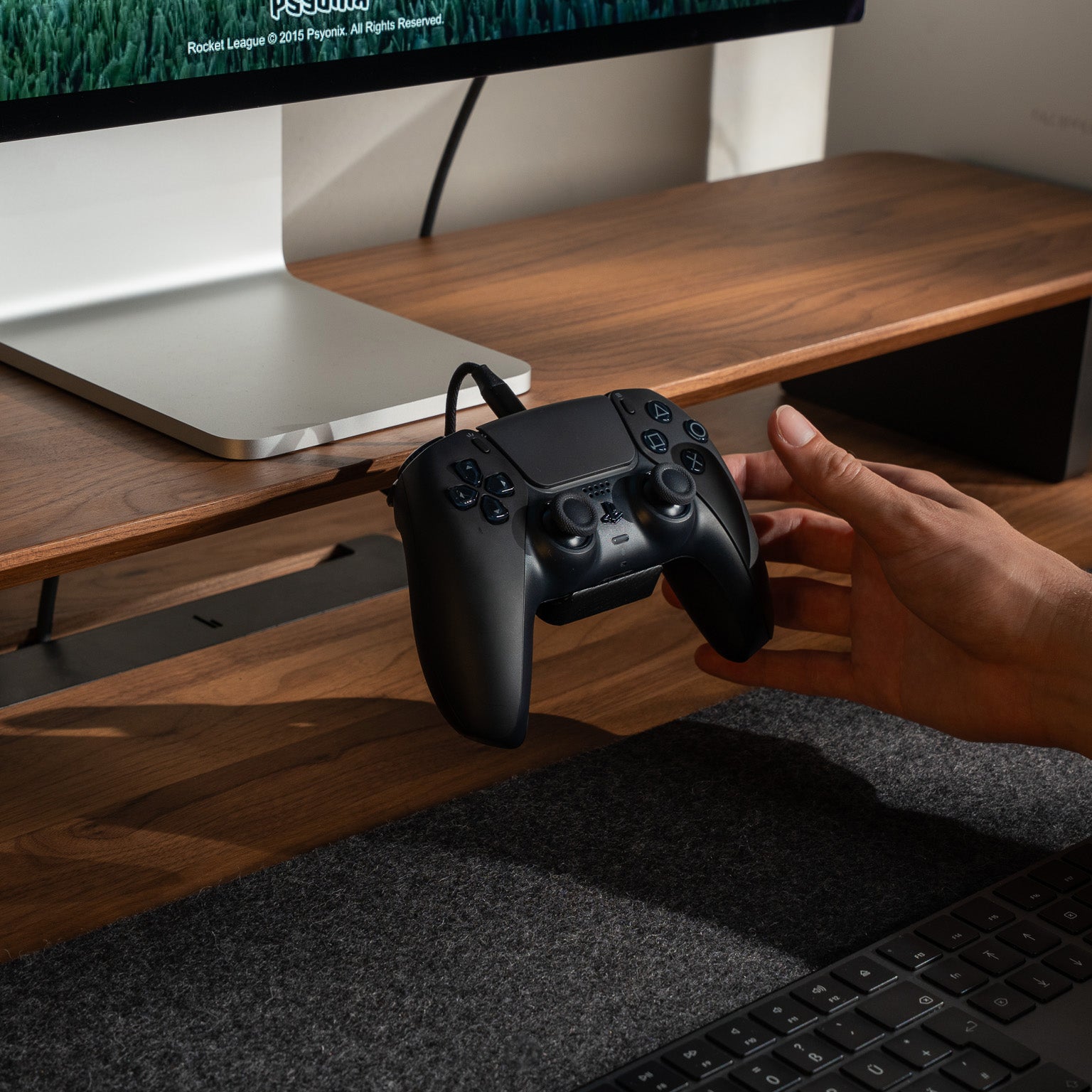 BALOLO Controller Halter mit PlayStation 5 Controller und Ladekabel montiert am Setup Cockpit in Nussbaum in ästhetischen Schreibtischsetup.