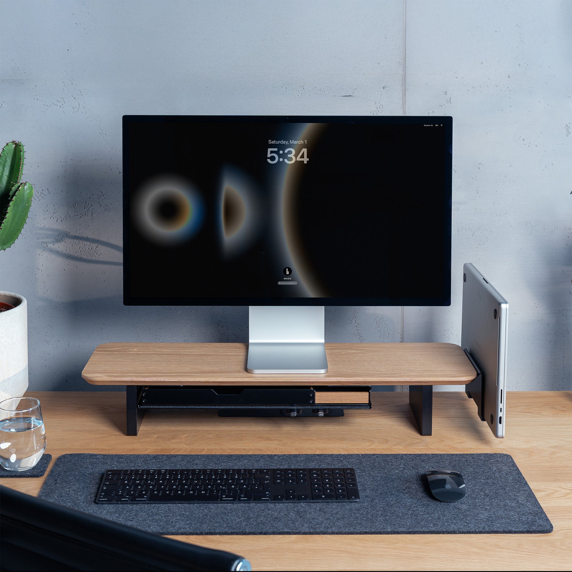 Setup Cockpit Monitorständer in Eiche auf einem Schreibtisch aus Eiche mit integriertem Laptophalter und Fach im modernen Office Setting.