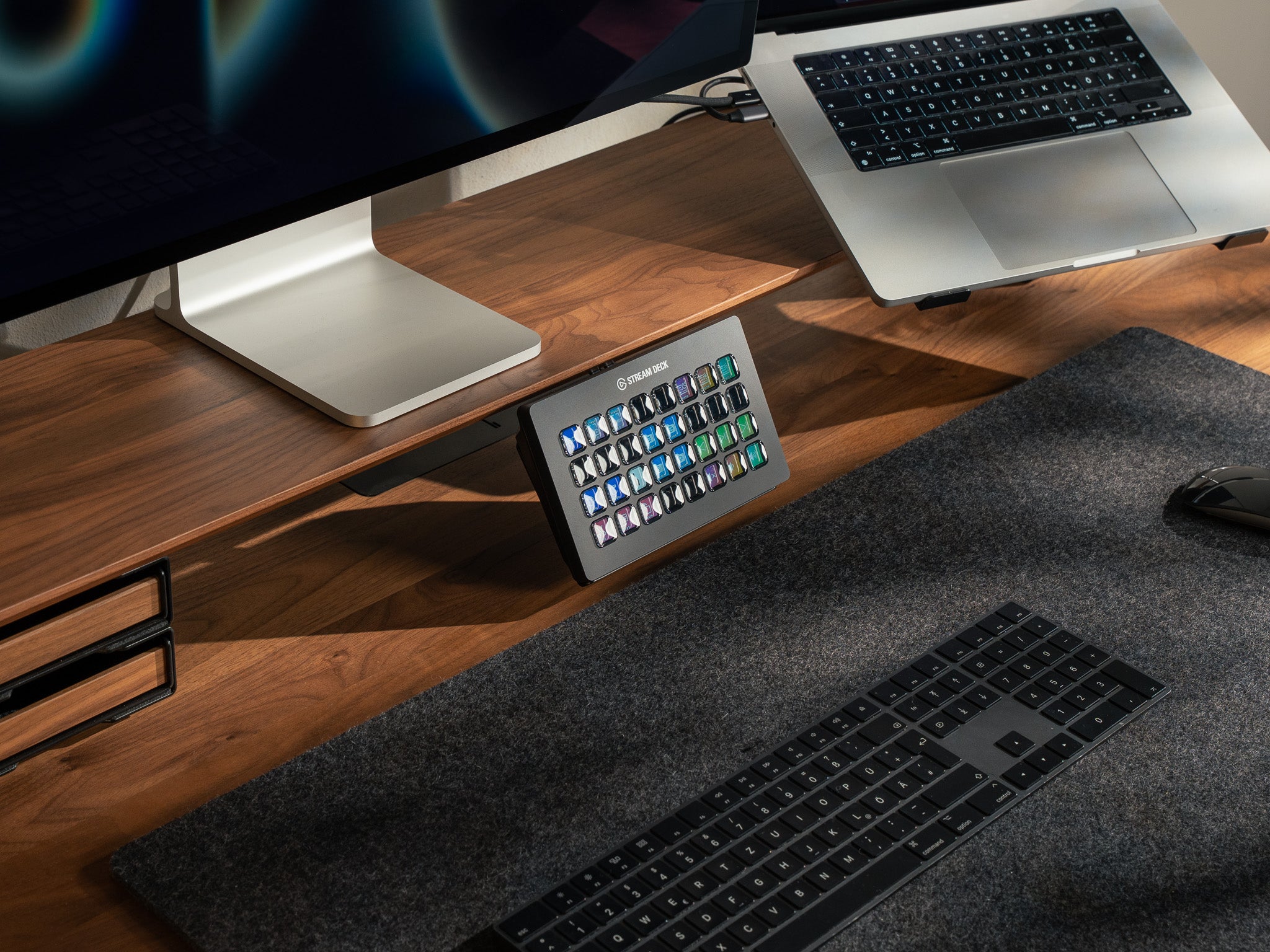 BALOLO Stream Deck XL Halter mit elgato Stream Deck XL, montiert an Setup Cockpit Monitorständer aus massivem Nussbaum in modernem Büro. Setup Cockpit Monitorständer ist veranschaulicht mit Laptophalterung, Apple Studio Display und Schubladen. @expand