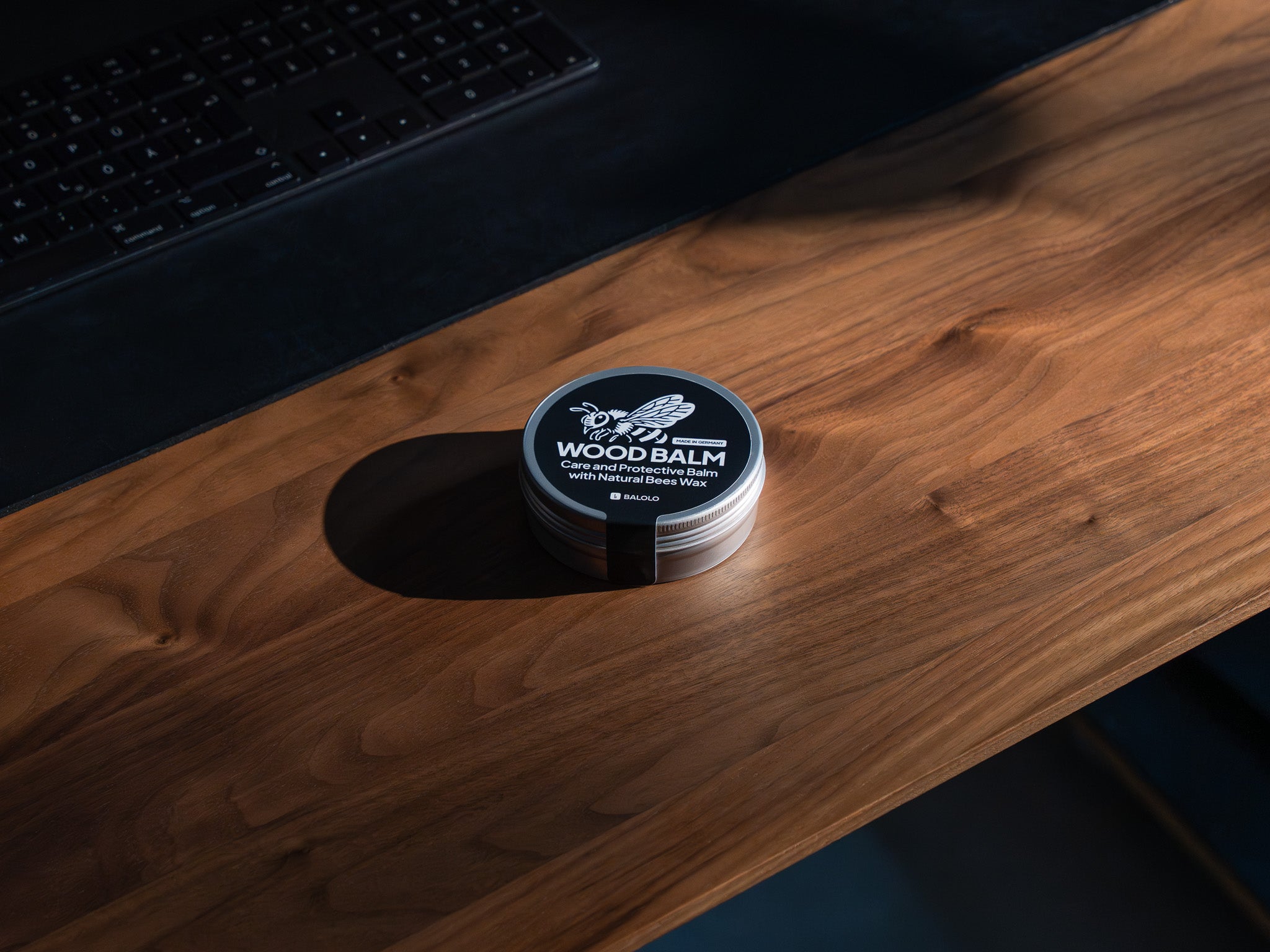 Detailaufnahme des Wood Balms. In Szene gesetzt auf Schreibtisch aus Nussbaum.