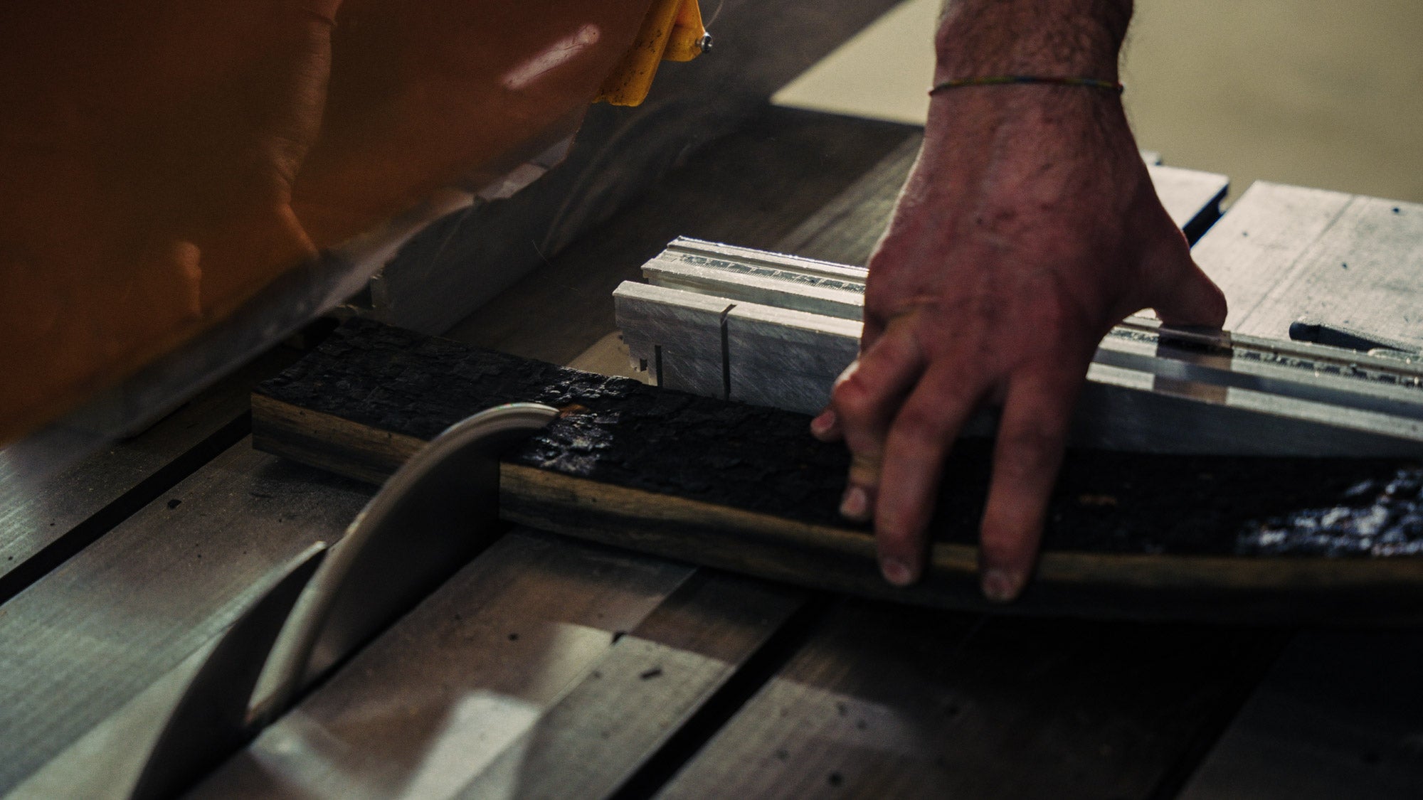 Nahaufnahme einer Fassdaube, die auf einer Säge klein gesägt wird.