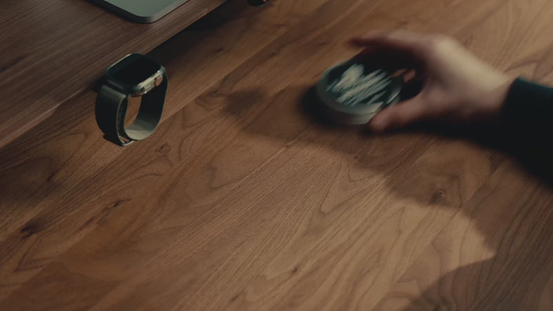 Detailaufnahmen der Wood Balm Holzpflege, Dose wird geöffnet und Pflege auf Schreibtisch aufgetragen.